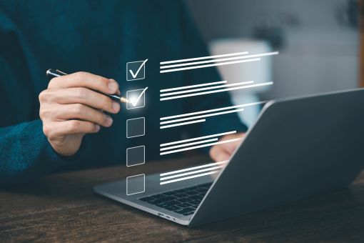 チェックリストにチェックする男性の手